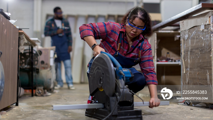 Carpenter working in carpentry shop. Carpenter working and steel cutting machine in wood workshop.