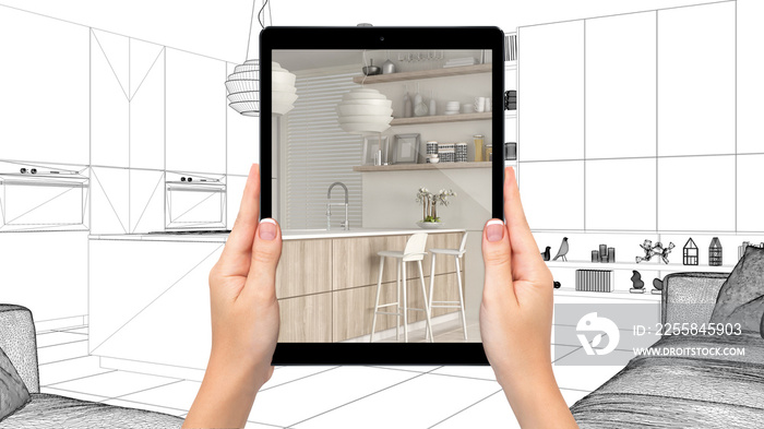 Hands holding tablet showing modern white and wooden kitchen. Blueprint CAD sketch background, augme