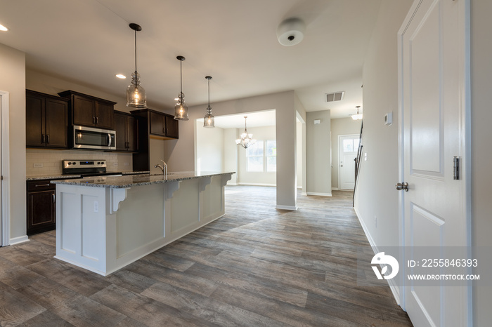 Empty modern townhouse floor showcasing a kitchen with living and dinning room ready to be moved in.