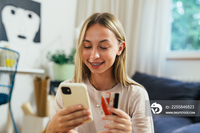 european teenager female shopping online using her mobile phone