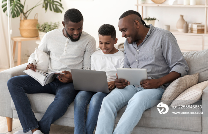 African Male Family With Laptop, Digital Tablet And Magazine At Home