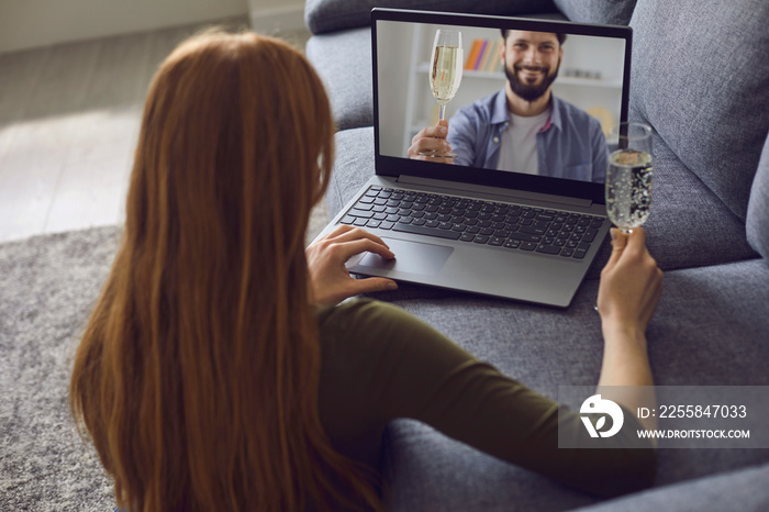 Online date dating. A young woman is in a living room with a laptop.