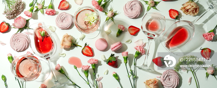 Wine, sweet food and flowers on white table