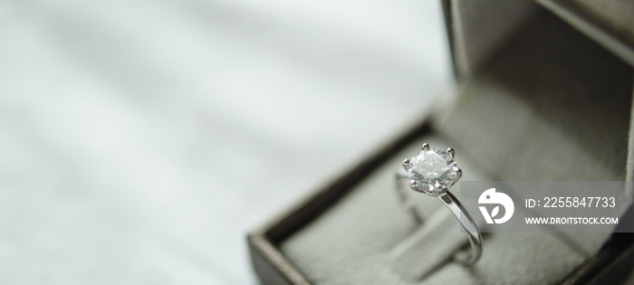 Diamond ring with jewelry gift box on white fabric background