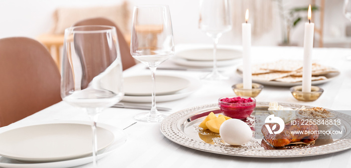 Passover Seder plate with traditional food on served table in dining room