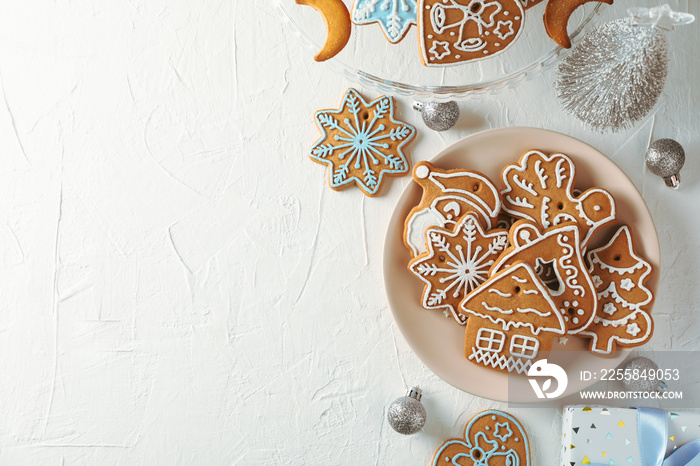 Plate with Christmas cookies, Christmas trees, toys, gift boxes on white background, top view. Space