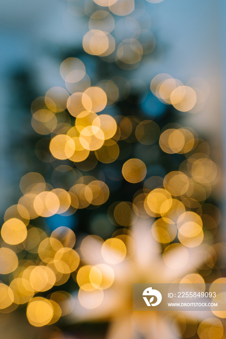 Christmas tree in interior with defocused lights and star. Christmas abstract blur background. Out o