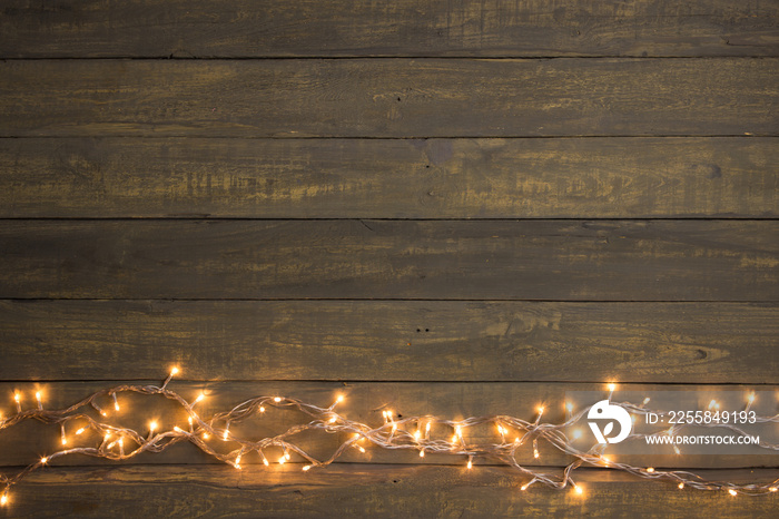 Christmas lights on a wooden background. Copy space for a greetings