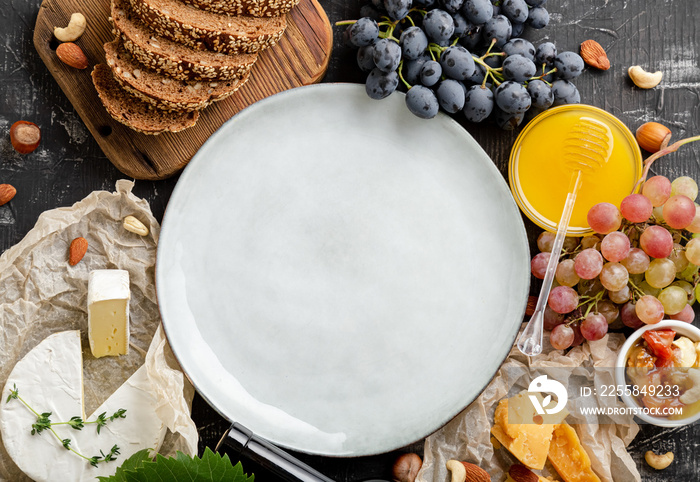 Empty mockup plate on abundance table with groceries. Mockup plate served in frame made of food for 