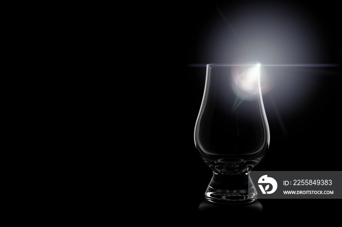 Shining whisky glass, silhouette of a whiskey glass with black background and interesting light effe