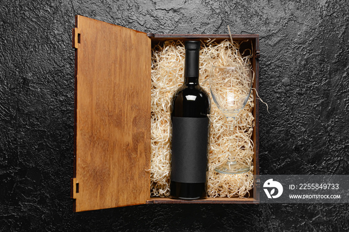 Box with bottle of wine on dark background