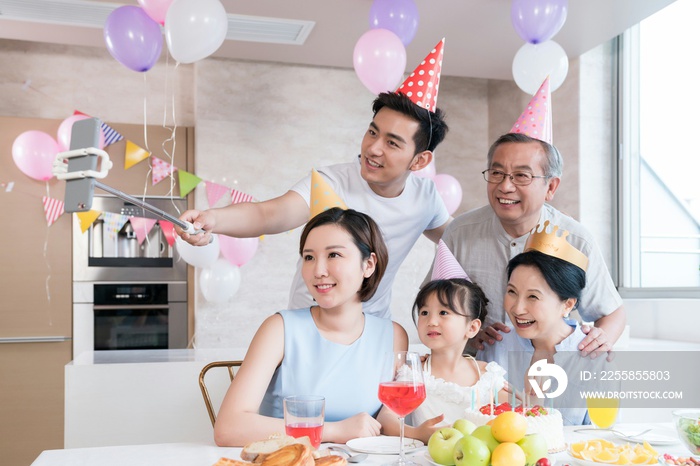 快乐的一家人在厨房聚会庆祝,拿着手机自拍