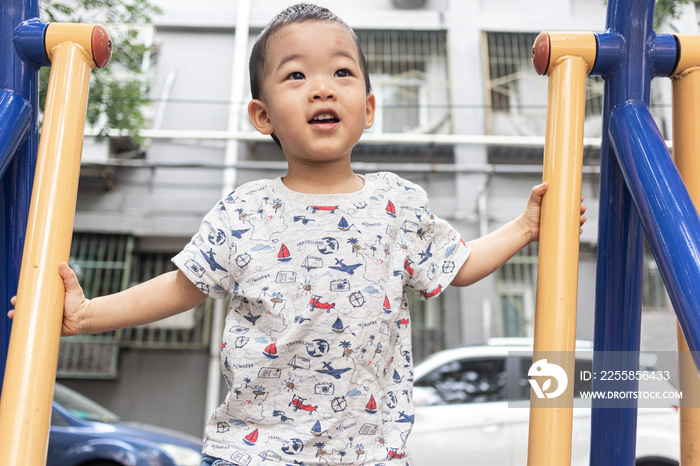 一个小男孩在院子里玩健身器械