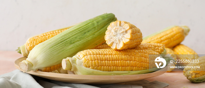 Plate with fresh corn cobs on table, closeup