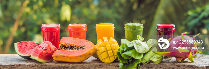 Rainbow from smoothies. Watermelon, papaya, mango, spinach and dragon fruit. Smoothies, juices, beverages, drinks variety with fresh fruits on a wooden table BANNER, long format