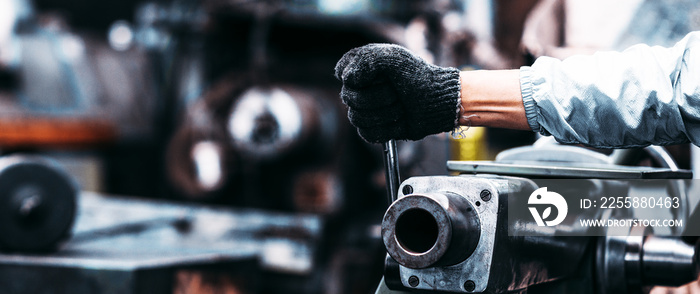 Close up hand industrial worker is working on metal work factory process performing mechanical turning operation at machine.