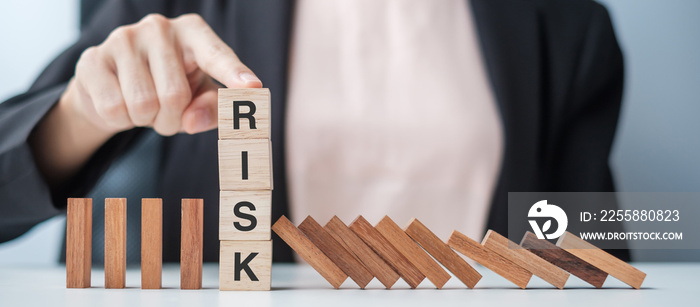 Businesswoman hand Stopping Falling wooden Blocks or Dominoes. Business, Risk Management, Solution, Insurance and strategy Concepts