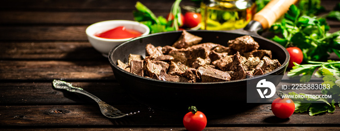 A frying pan with cooked liver on the table.