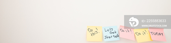 Do it now. A conceptual written message on sticky notes on white wall. Motivation phrases