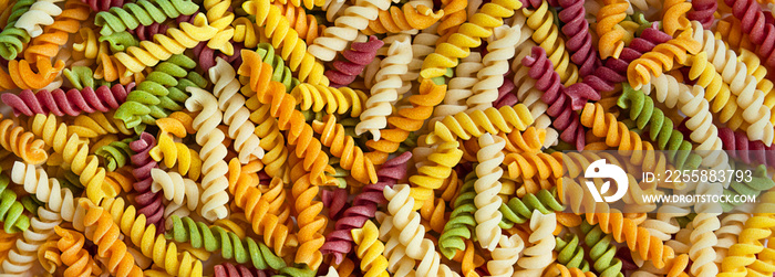 Colored Italian pasta on a white background. Children’s paste with natural dyes from vegetables and herbs. Pasta background.Banner.