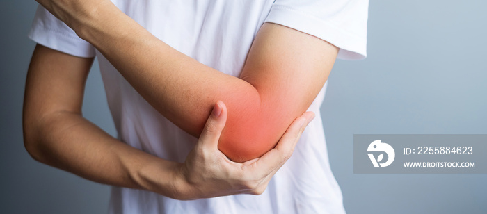 Young adult female with her muscle pain on gray background. Woman having elbow ache due to lateral epicondylitis or tennis elbow. injuries and medical concept