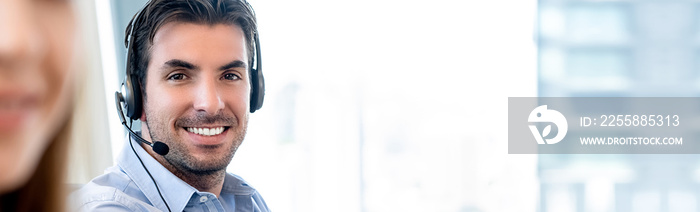 Smiling friendly Hispanic man working in call center