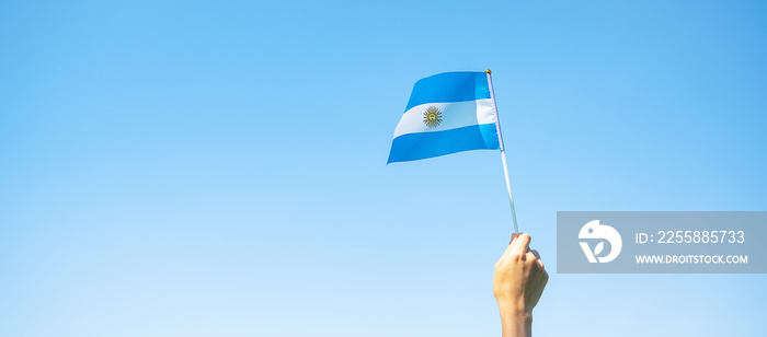 hand holding Argentina flag on nature background. 9th July of Independence day, 25th May of Revolution day and happy celebration concepts