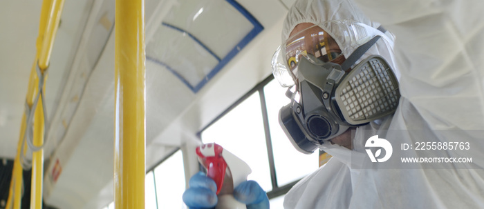 HazMat team in protective suits decontaminating public transport, bus interior during virus outbreak