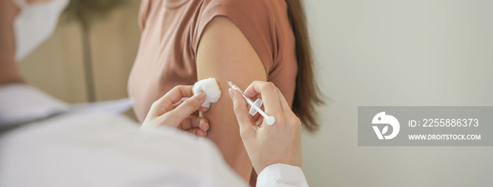 Covid-19,coronavirus hand of young woman nurse,doctor giving syringe vaccine, inject shot to asian arm’s patient. Vaccination, immunization or disease prevention against flu or virus pandemic concept.