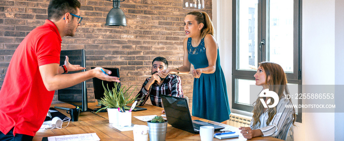 Young coworkers arguing standing in the office