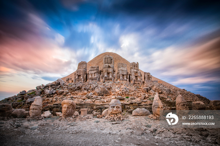 East terrace of Mount Nemrut at sunrise with Great alter in front of statues and the tumulus. The UNESCO World Heritage Site at Mount Nemrut where King Antiochus of Commagene is reputedly entombed.