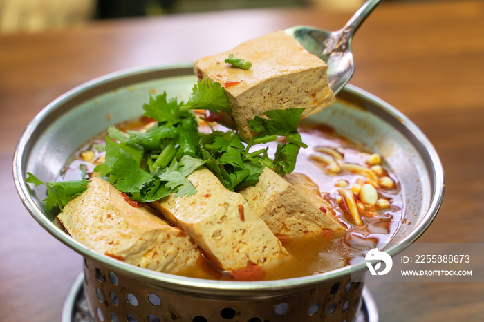 Eating stinky tofu hot pot with spicy soup.