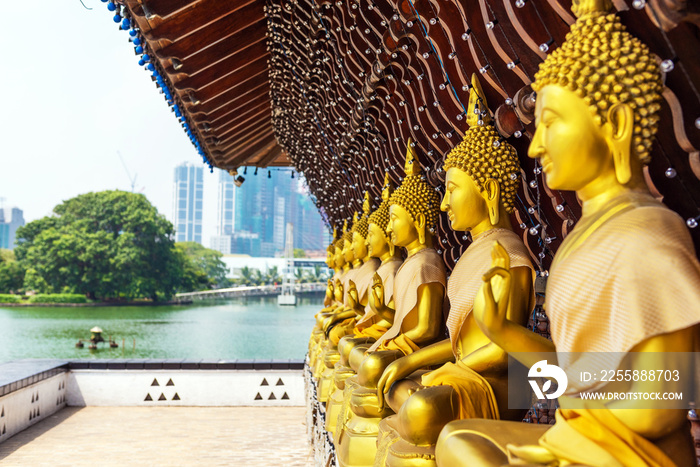 Golden Buddha statues in the courtyard of the temple Gangaramaya, Colombo, Sri Lanka. With selective focus.