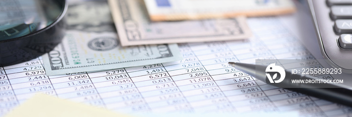 Money and calculator lying on table with numbers closeup