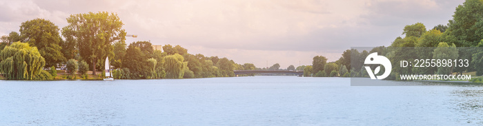 Scenic panorama of Aasee lake or pond with sailing boat in Munster city park. Leisure and recreation with yacht or sailboat