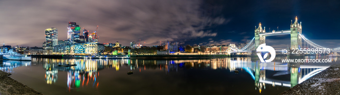 Tower Bridge and financial district of London at night. England