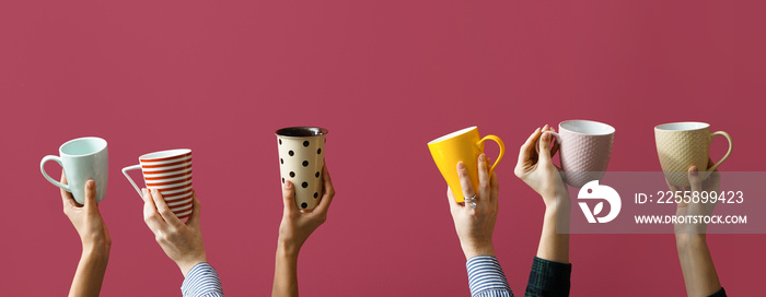 Female hands with many cups on color background