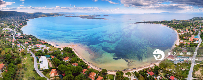 Aerial panoramic scenic view of azure blue lagoon and paradise bay with majestic patterns on a sea shelf. Resort village of Vourvourou on Sithonia peninsula in Halkidiki, Greece