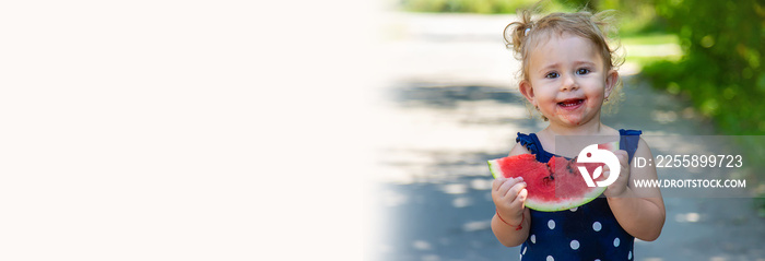 A child eats watermelon in the park. Selective focus.