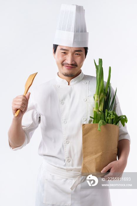 穿着厨师服的中年男人抱着蔬菜