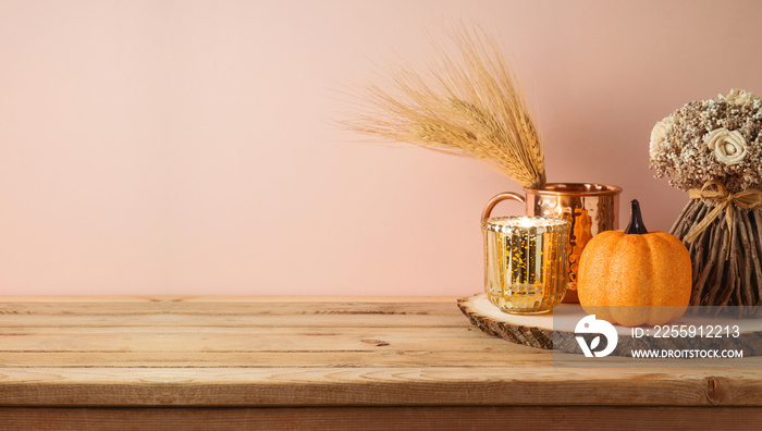 Autumn season concept with pumpkin decor and candle on wooden table. Halloween or Thanksgiving greet