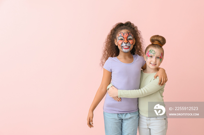 Funny little children with face painting on color background