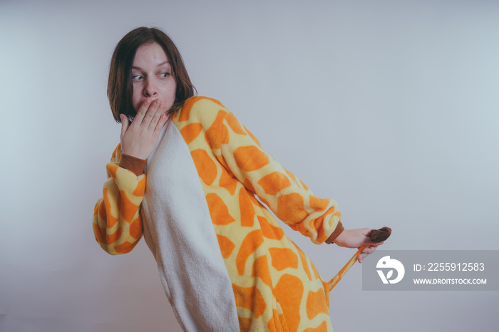 pajamas in the form of a giraffe. emotional portrait of a girls on an orange background. crazy and f