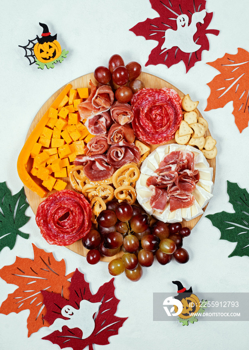 halloween charcuterie  board with swith cheese and meat snacks, grapes and crackers party