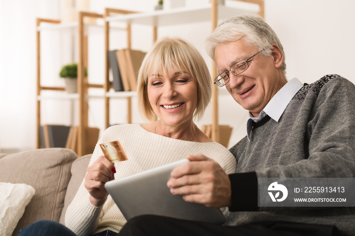 Senior couple shopping online with tablet and credit card