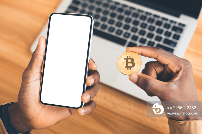 African american guy holding golden bitcoin and phone