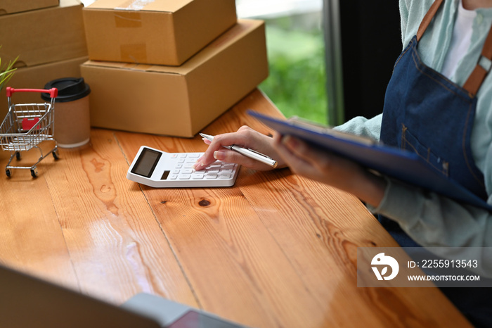 Close up with mall business owner working with calculator, The seller prepares the delivery box for 