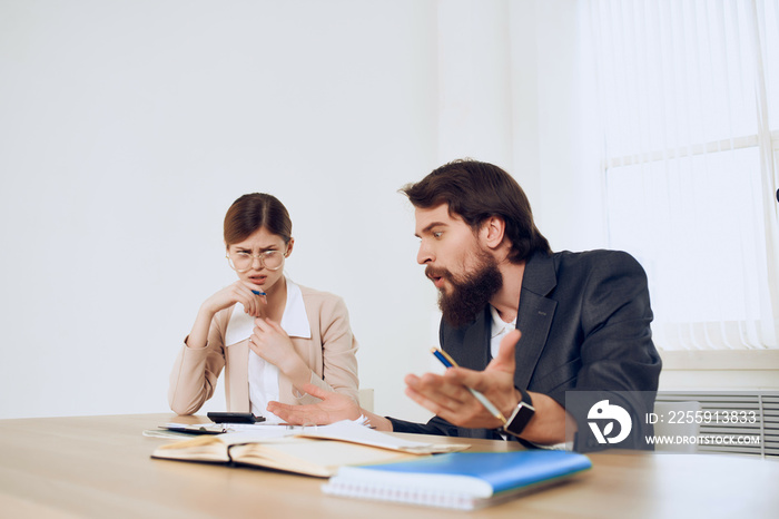 man and woman sitting at the desk communication emotions work colleagues dissatisfaction