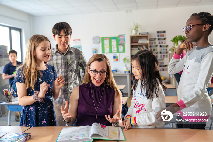 教师辅导小学生在教室里学习