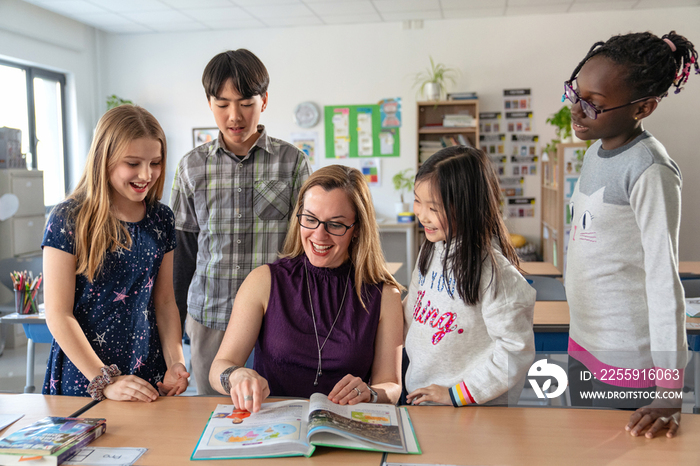 教师辅导小学生在教室里学习